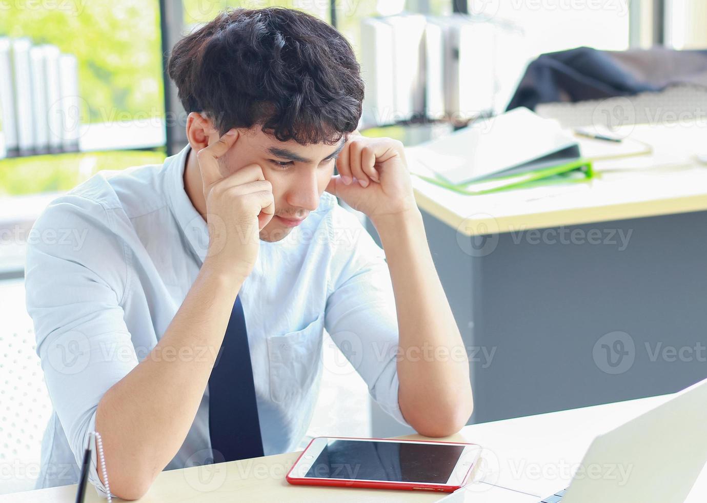 ung affärsman som arbetar på kontoret med stress foto