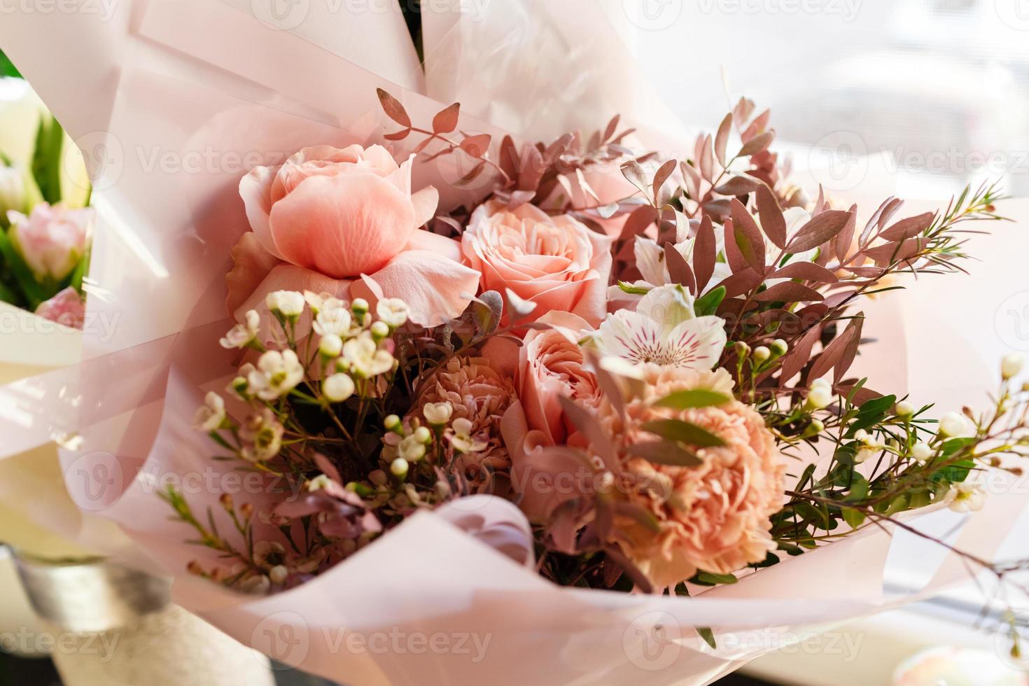 vackert förpackade blomma arrangemang för berömd mödrar dag, födelsedag, årsdag, kvinnors dag i en festlig papper paket. de begrepp av en blomma affär och blomma leverans, blomsterhandlare arbete foto