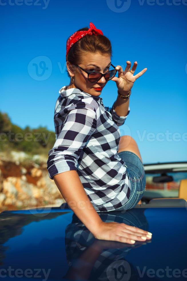 skön stift upp kvinna Sammanträde i cabriolet, njuter resa på lyx modern bil med öppen tak foto