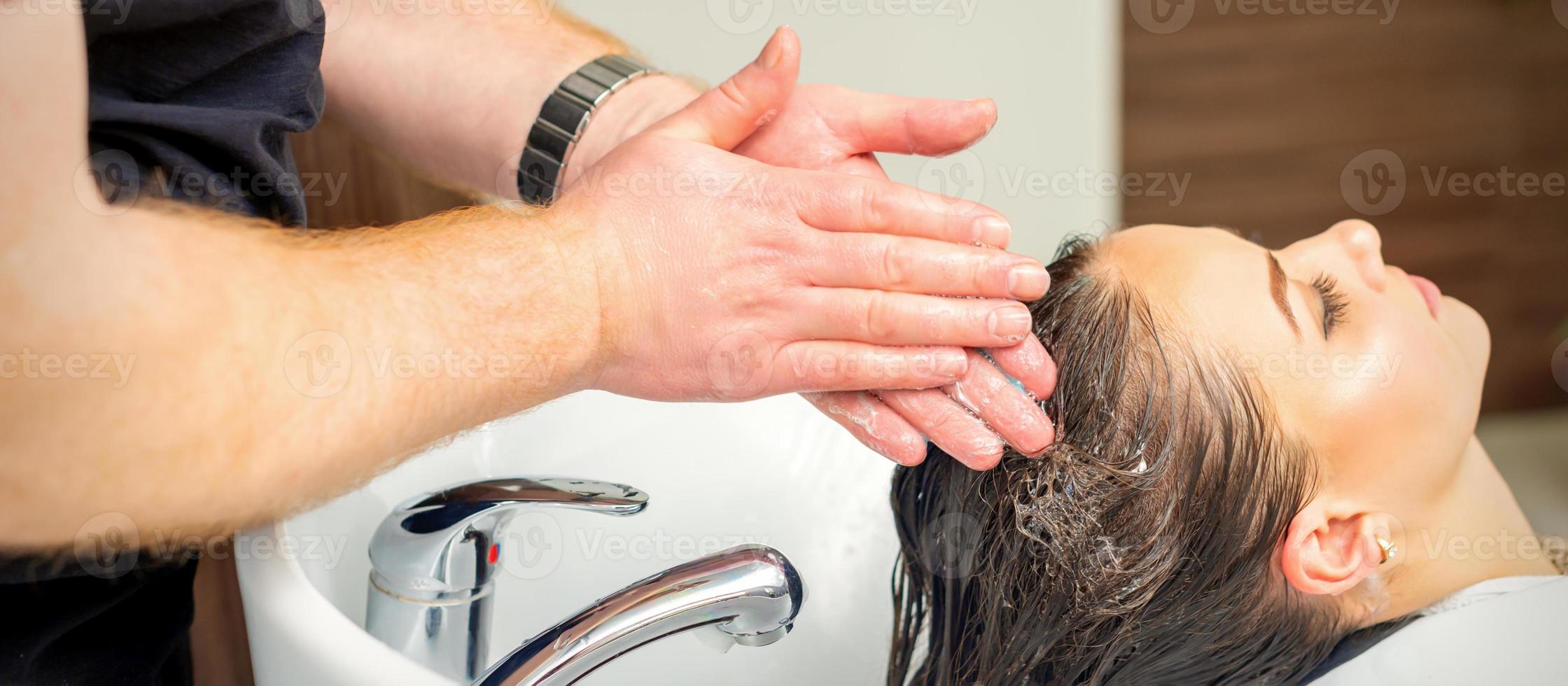 ung kvinna tvättning henne hår foto