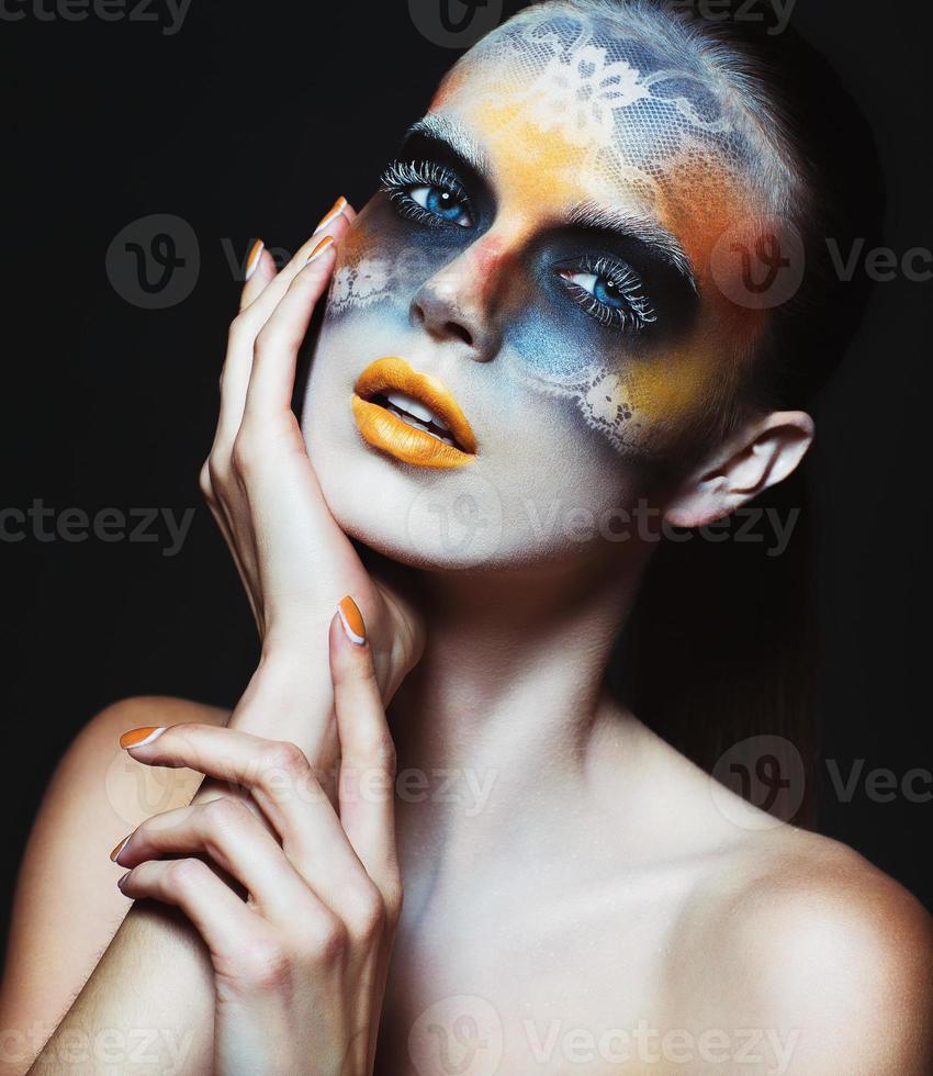 porträtt av skön glamour flicka med mörk öga smink i de form av spets och orange mun foto