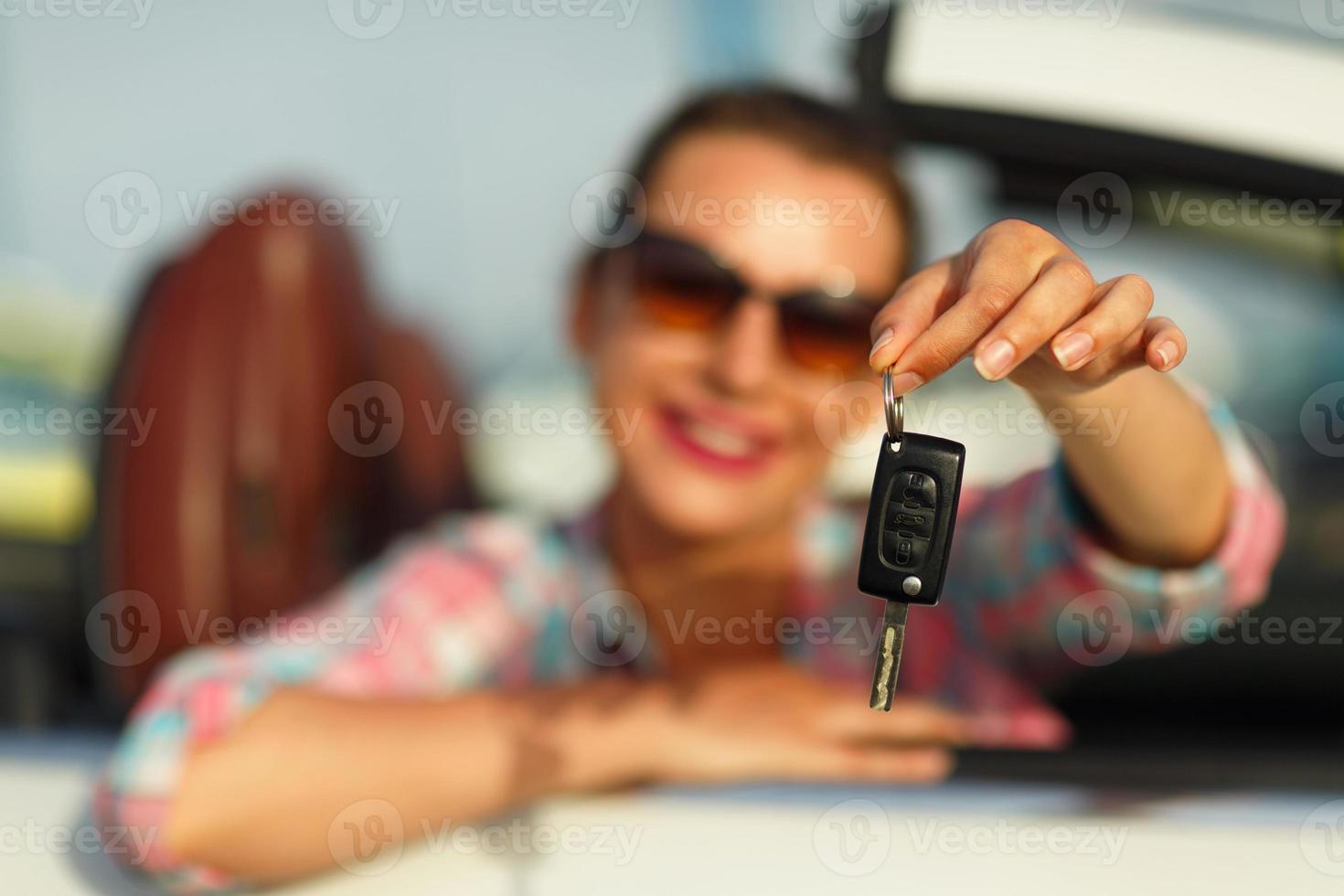 kvinna Sammanträde i en konvertibel bil med de nycklar i hand - begrepp av uppköp en Begagnade bil eller en uthyrning bil foto