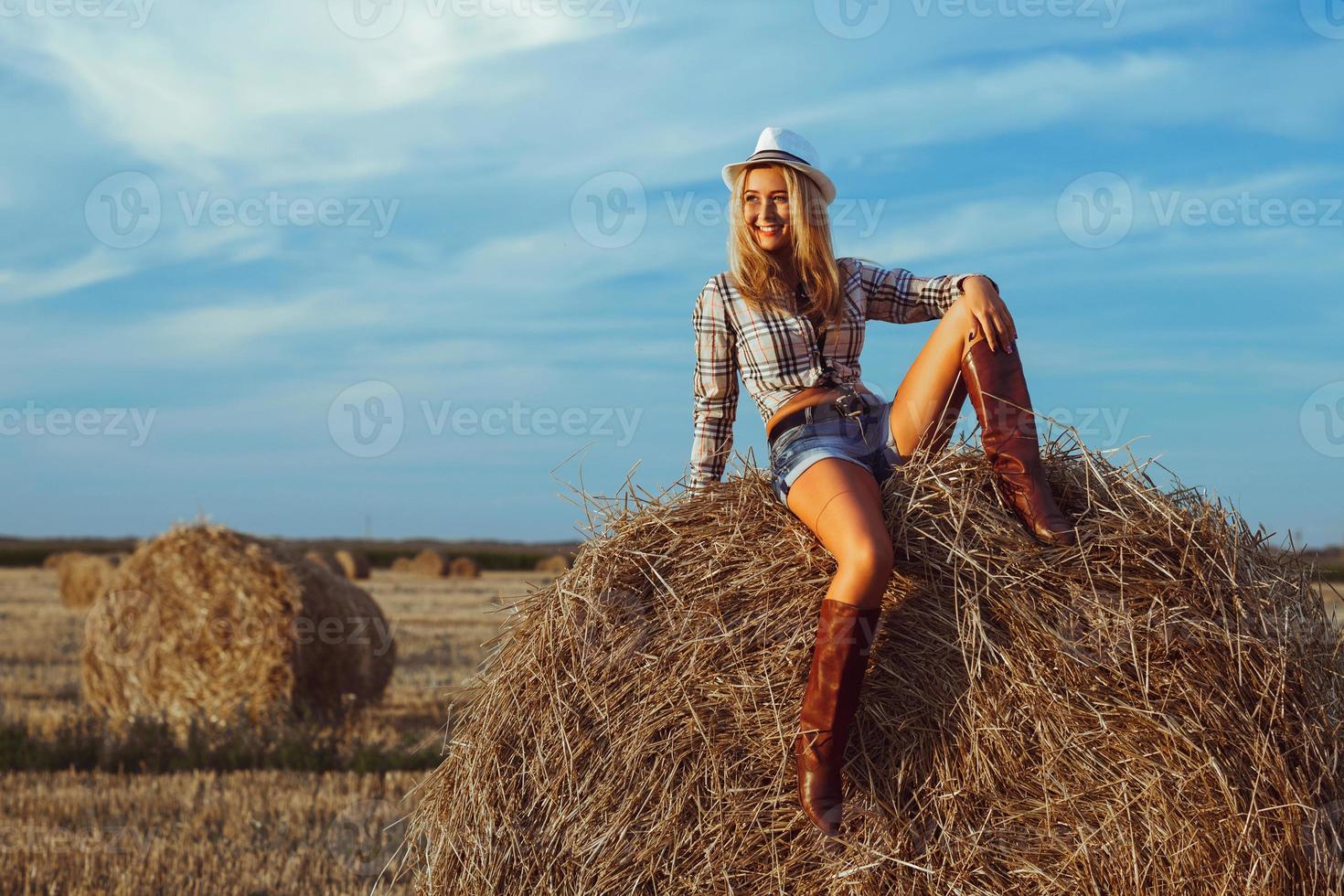 härlig mode kvinna i ko flicka Land stil på hö stack foto