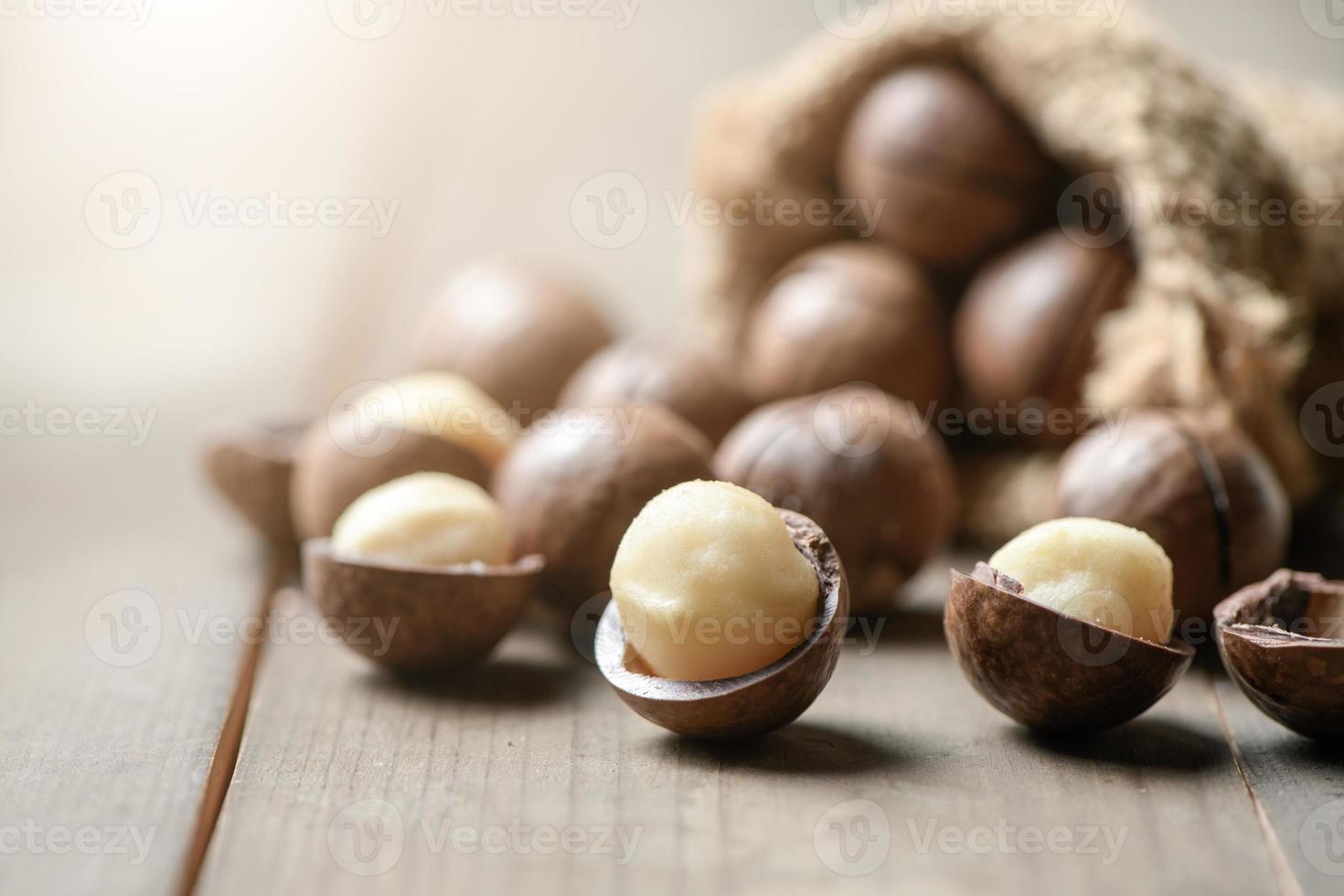 skalad macadamia nötter på trä bakgrund, macadamia nötter är lastad med flavonoider och tokotrienoler och rik i hjärt-friska enkelomättad fett foto