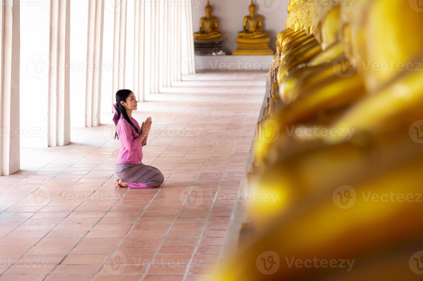 asiatisk kvinna till betalande respekt till buddha staty i ayutthaya, thailand. foto