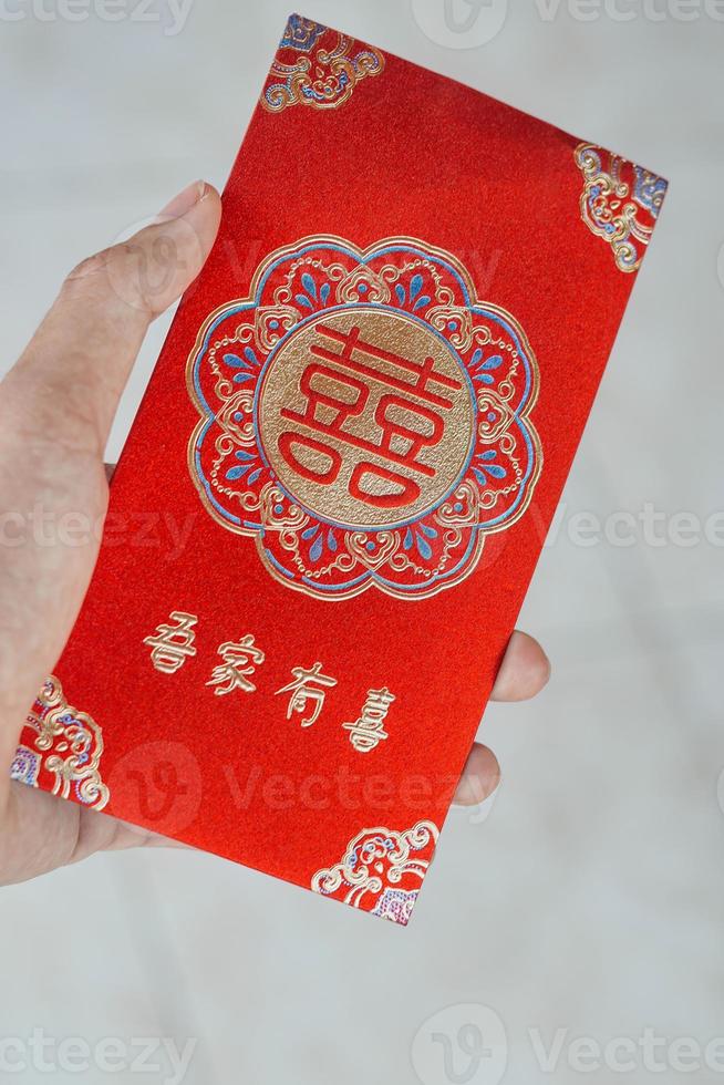 hand innehav röd kuvert gåva kinesisk ny år foto
