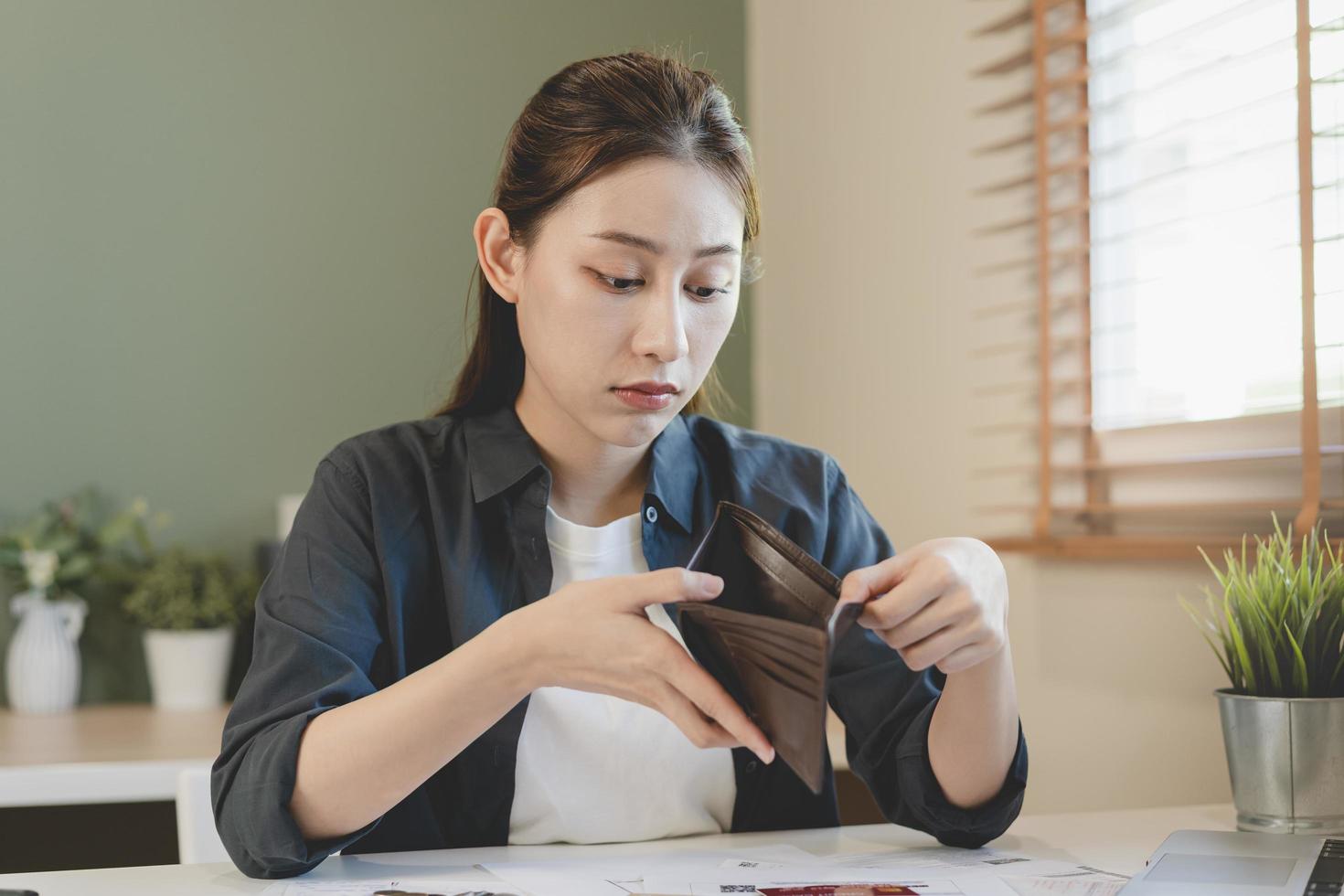 stressad, problem människor asiatisk kvinna, flicka innehav och öppen ett tömma plånbok inte ha pengar, kreditera kort, inte till betalning räkningen, lån eller bekostnad i betala. konkurs, bankrutt och skuld finansiell begrepp. foto