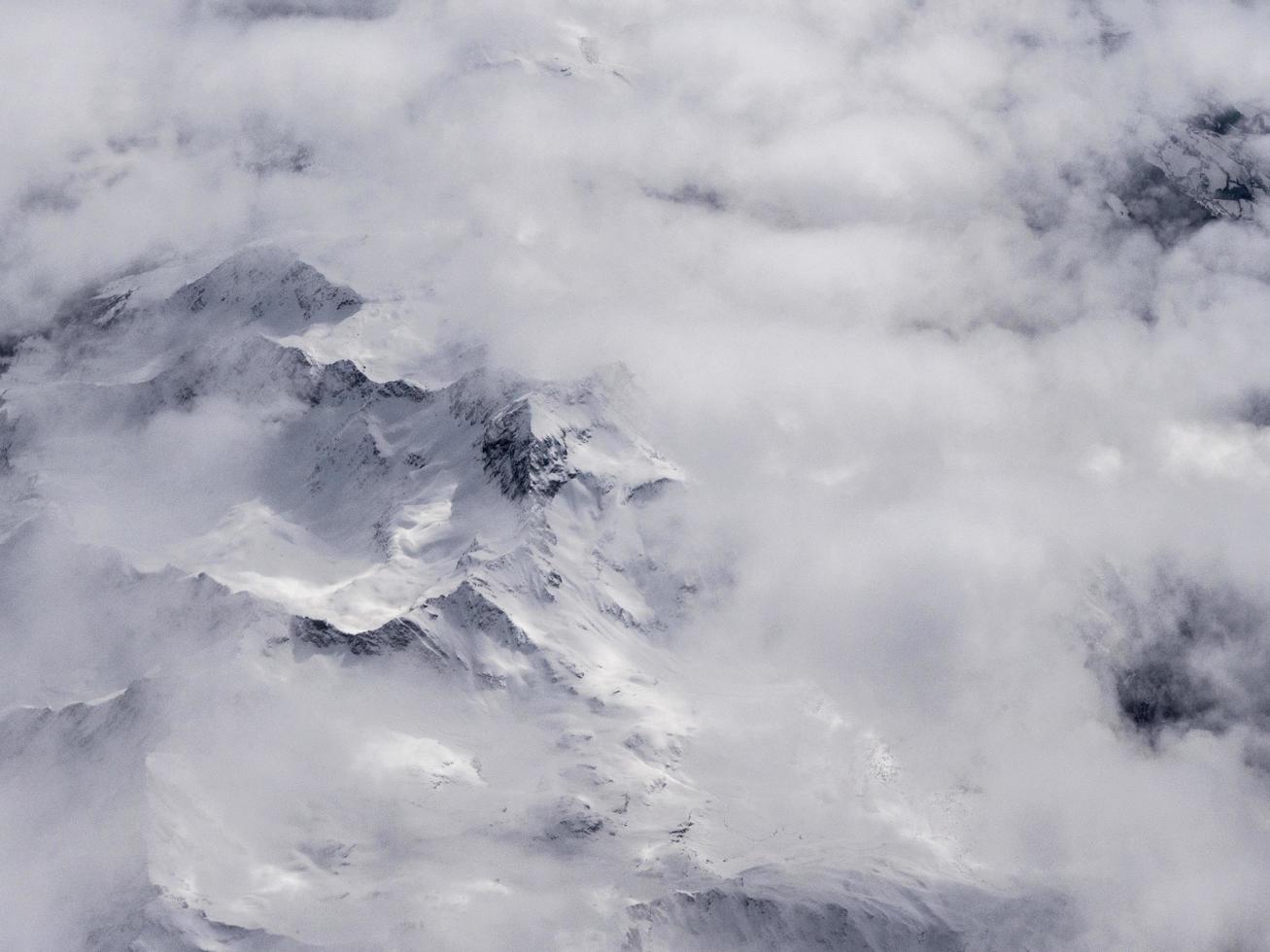 Flygfoto över berg täckt av moln eller dimma foto
