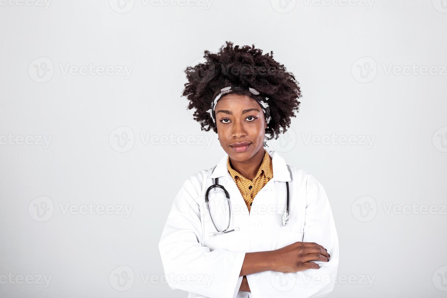 medicin, yrke och sjukvård begrepp - Lycklig leende afrikansk amerikan kvinna läkare i vit täcka med stetoskop över bakgrund foto