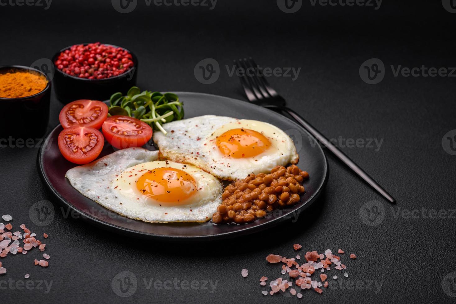 utsökt hjärtlig frukost bestående av två friterad ägg, konserverad linser och mikrogrönsaker foto