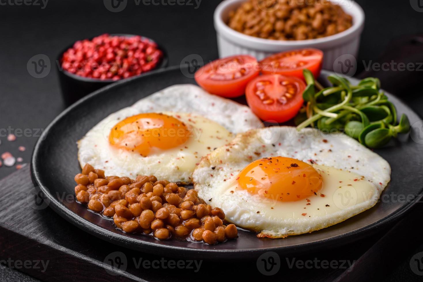 utsökt hjärtlig frukost bestående av två friterad ägg, konserverad linser och mikrogrönsaker foto