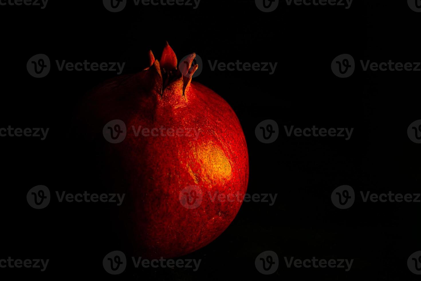 mogen granatäpple frukt på en svart bakgrund stänga upp foto