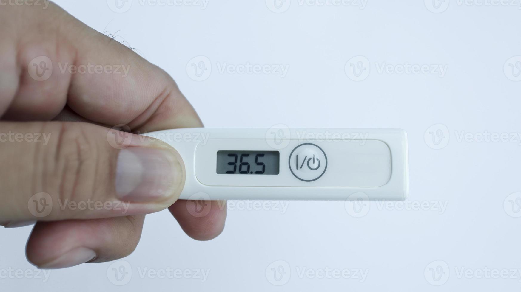 innehav digital termometer isolerat på vit Begagnade till mäta kropp temperatur den där är som visar vanligt temperatur. foto