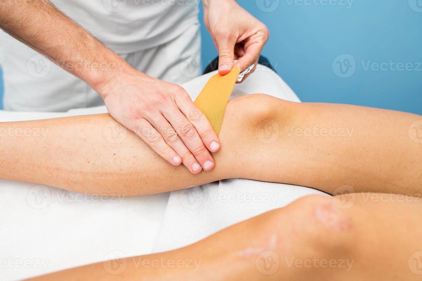 kinesio taping knä applicering av en sjukgymnast foto