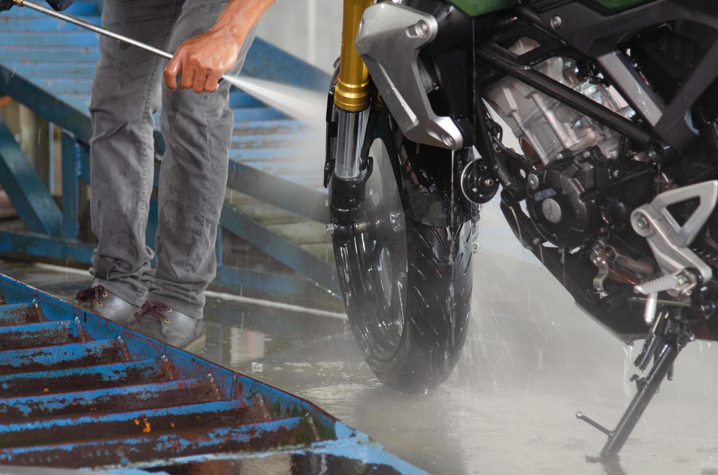 person som tvättar en motorcykel foto