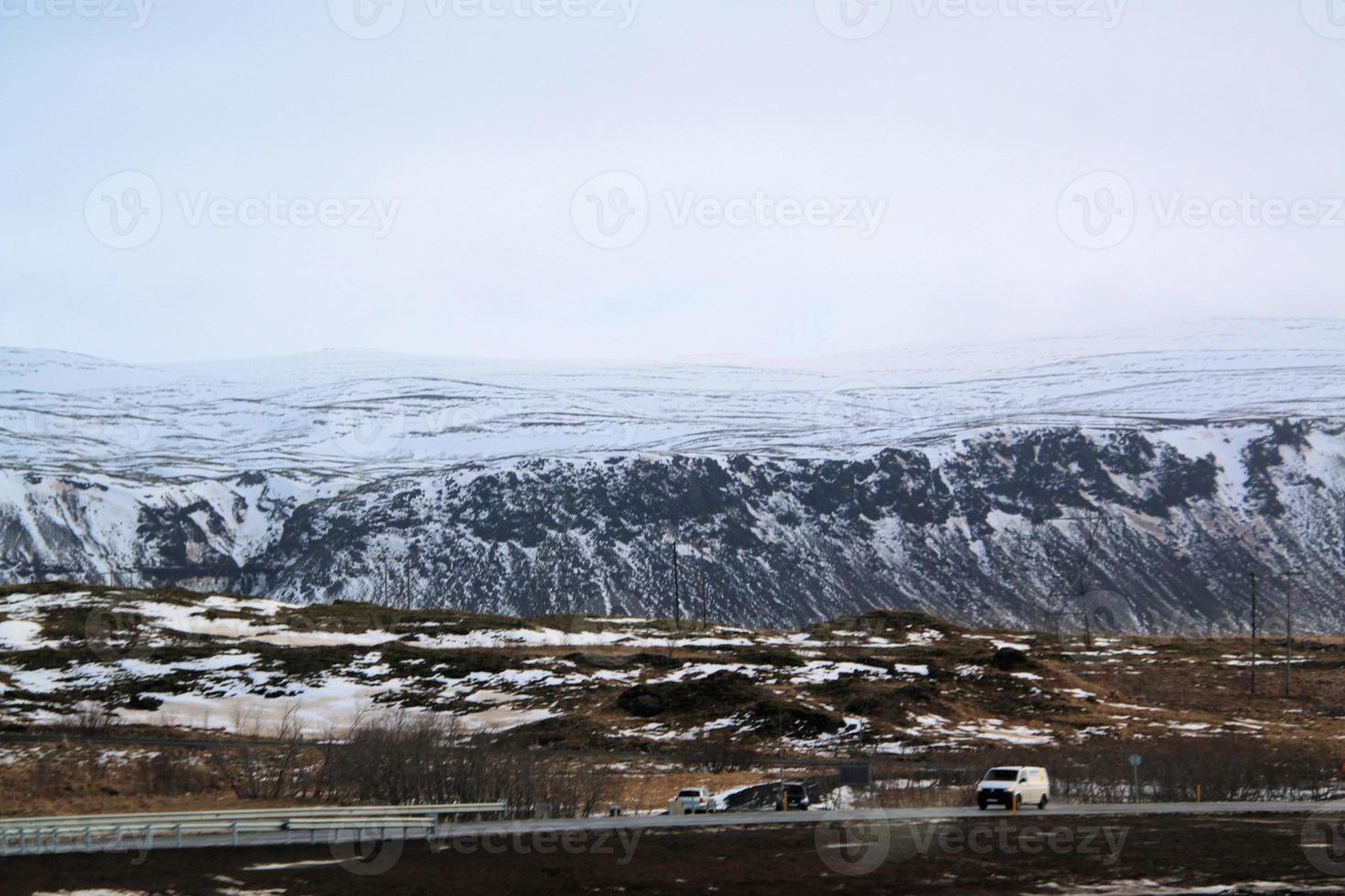 isländsk landskap med snö täckt bergen och moln i vinter. foto