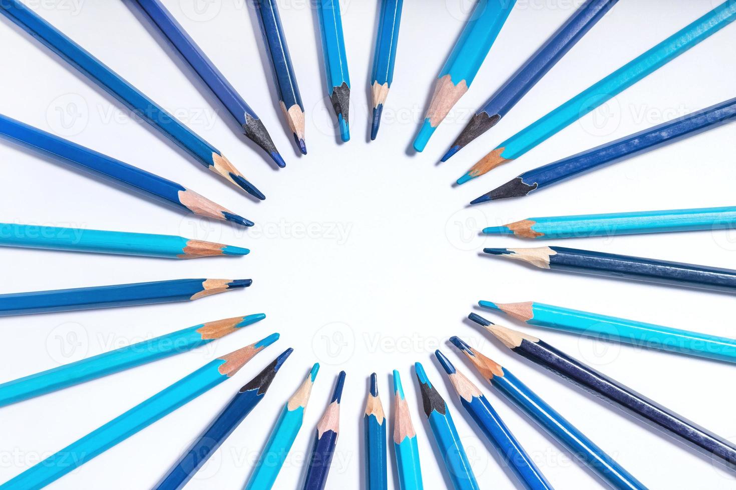 blå pennor fodrad upp i en cirkel på en vit bakgrund. Foto med runda ram för kopia Plats