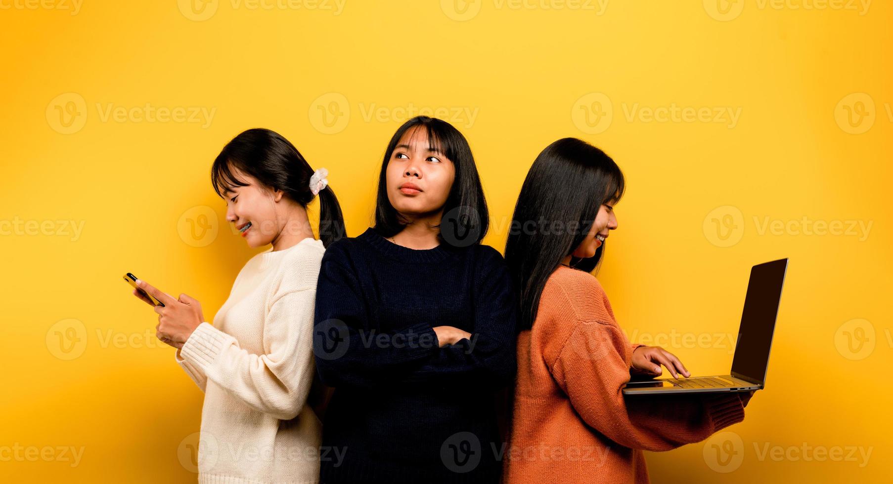 två asiatisk kvinnor arbetssätt på bärbar dator och telefon. på de samma tid två av dem var kommunicerar uppkopplad och som visar Lycklig ler. och gör inte vård handla om de människor runt om honom och hans vänner uppkopplad foto
