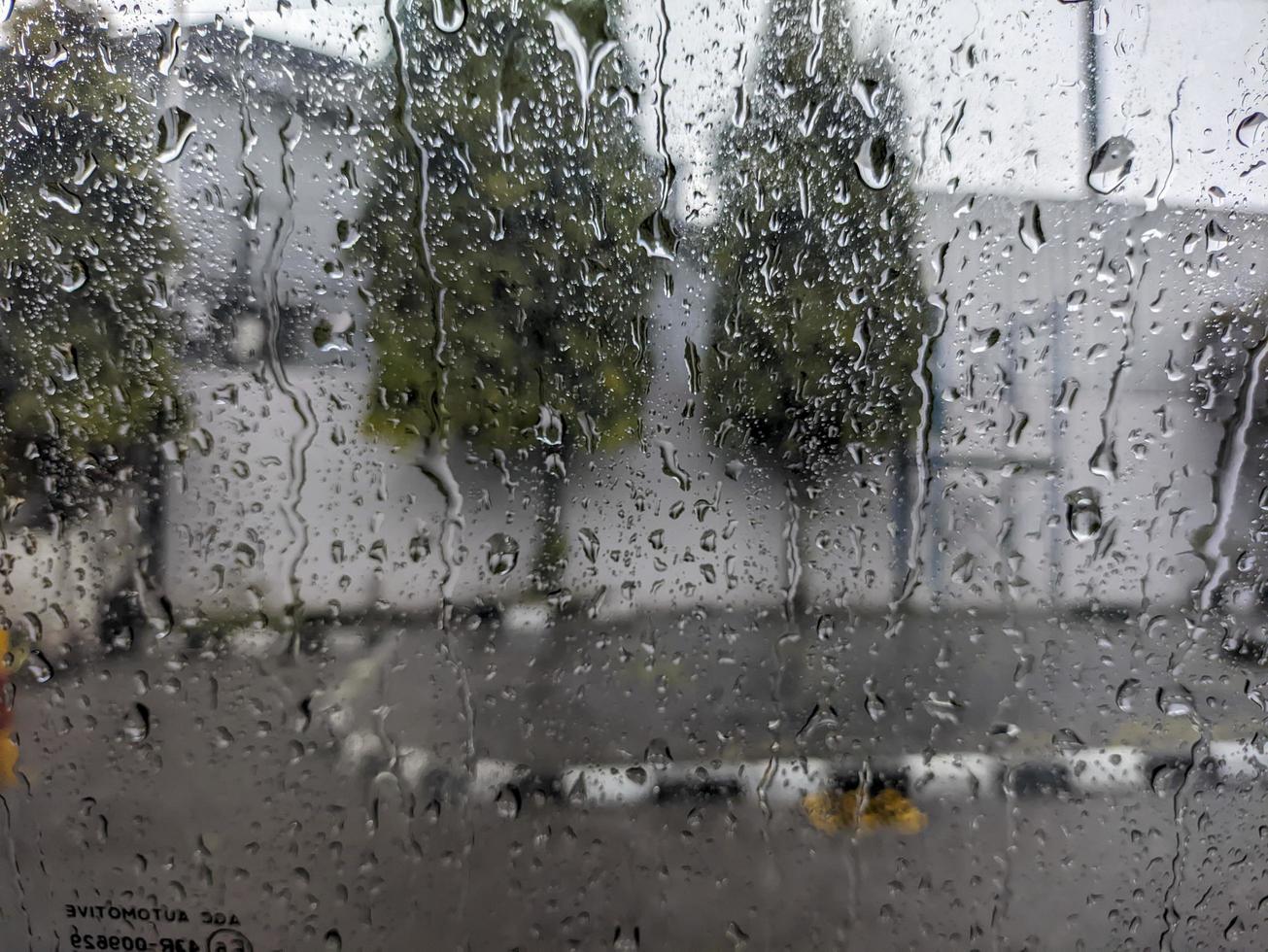 en regndroppar droppande ner de vindskydd av de bil. för regndroppar bakgrund. Nej människor foto