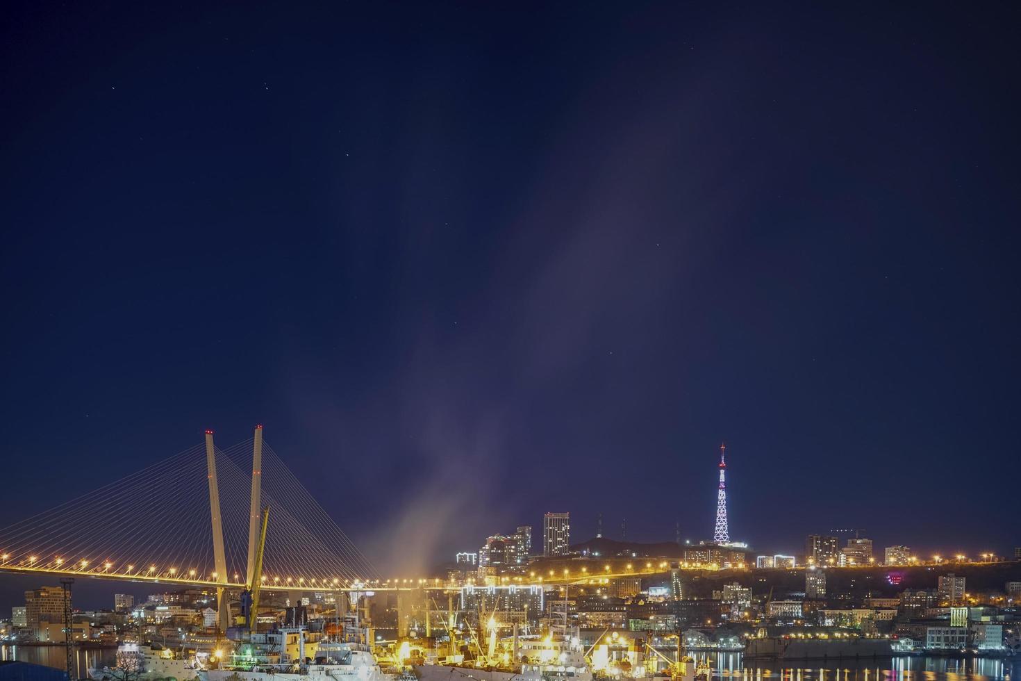 nattstadslandskap av den gyllene bron i Vladivostok, Ryssland foto