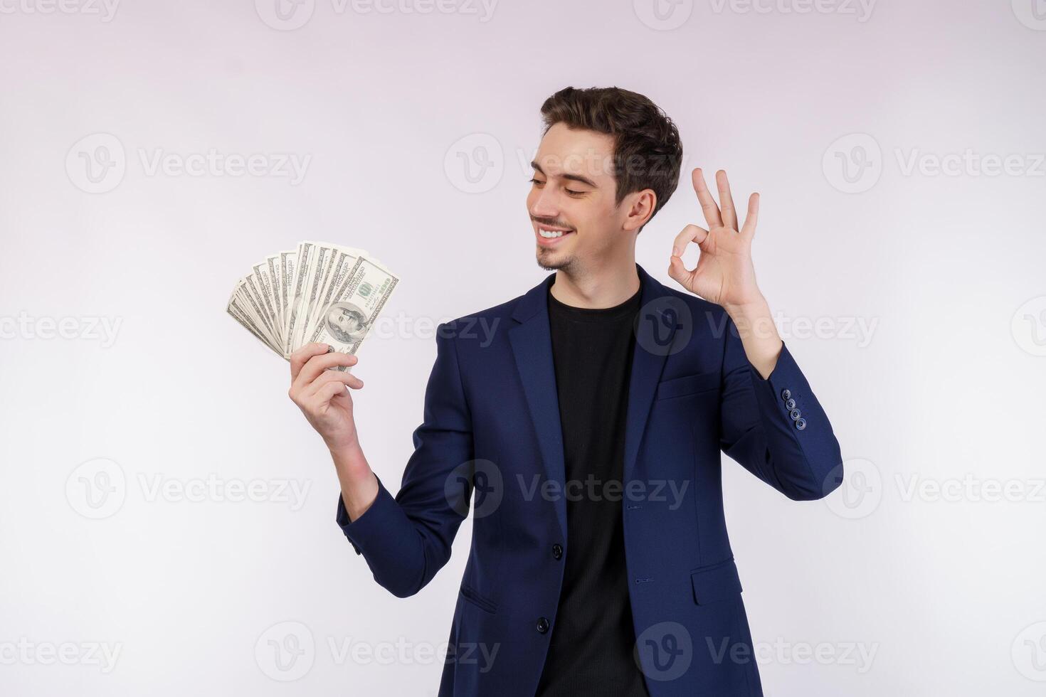 porträtt av en glad man som visar ok tecken och innehav pengar över vit bakgrund foto