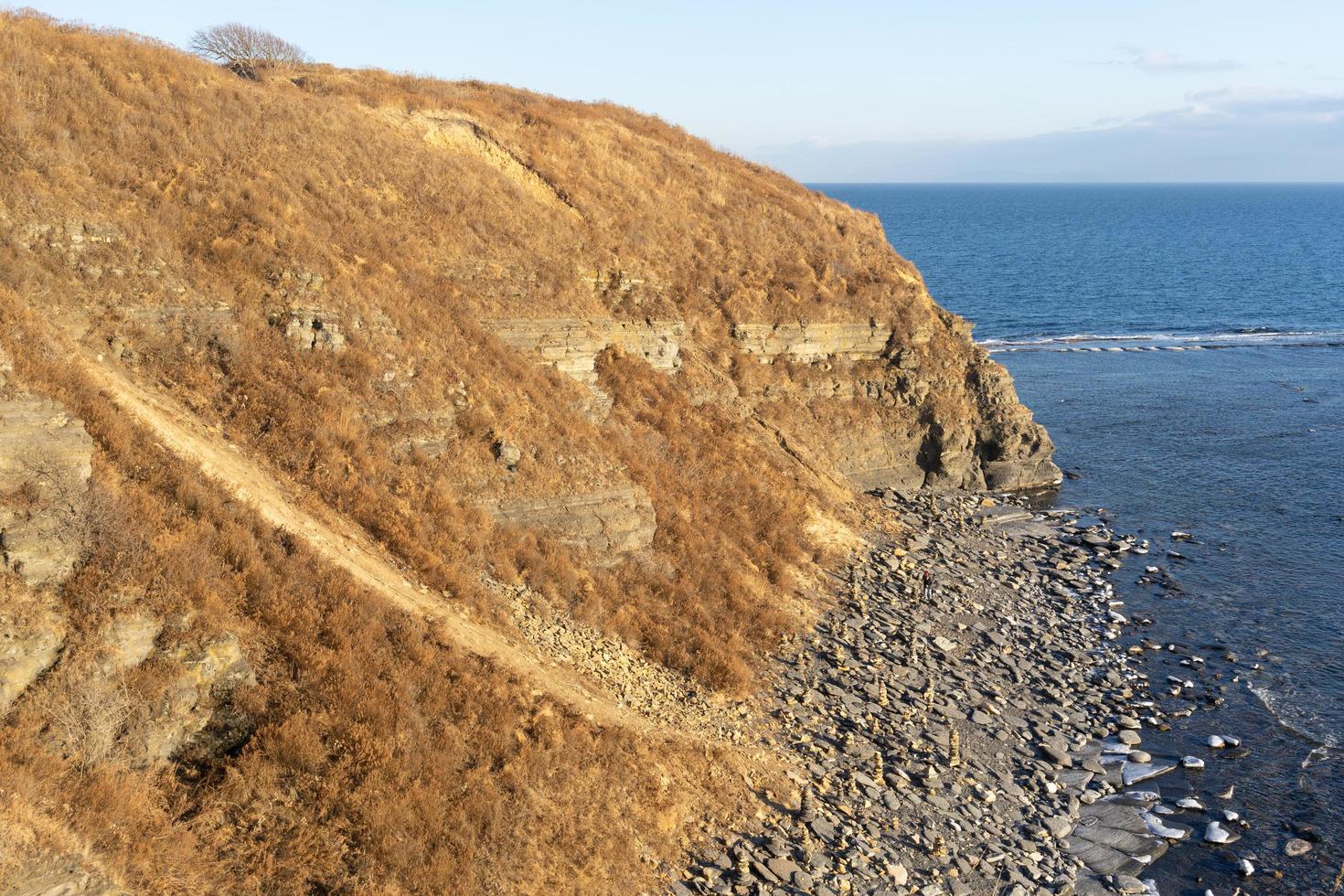 marinmålning av en stenig kust och vatten i Vladivostok, Ryssland foto