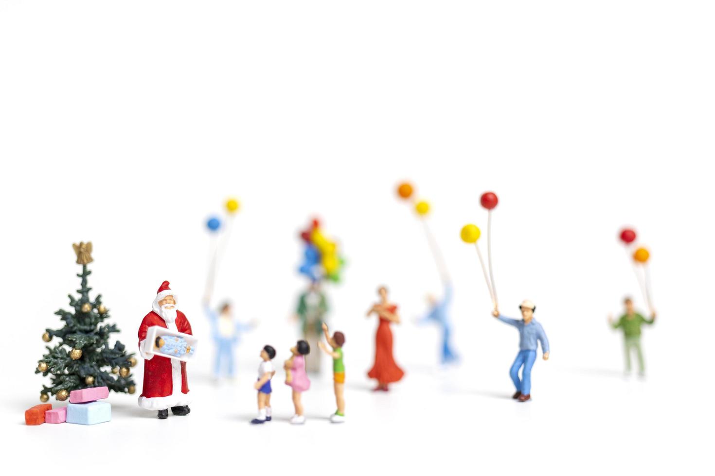 miniatyr Santa Claus håller gåvor för en lycklig familj, jul och gott nytt år koncept foto