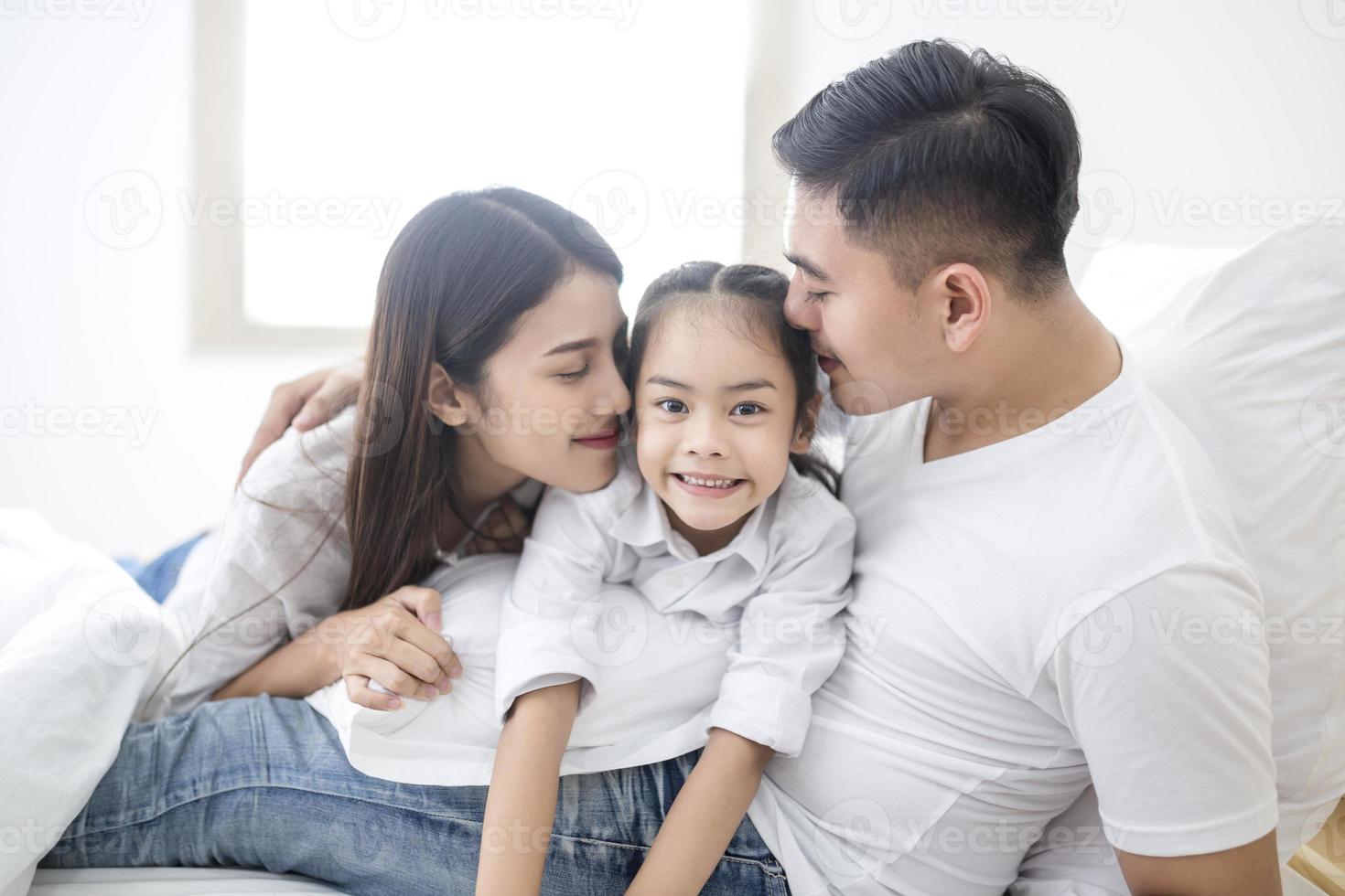 föräldrar och dotter omfamnar foto