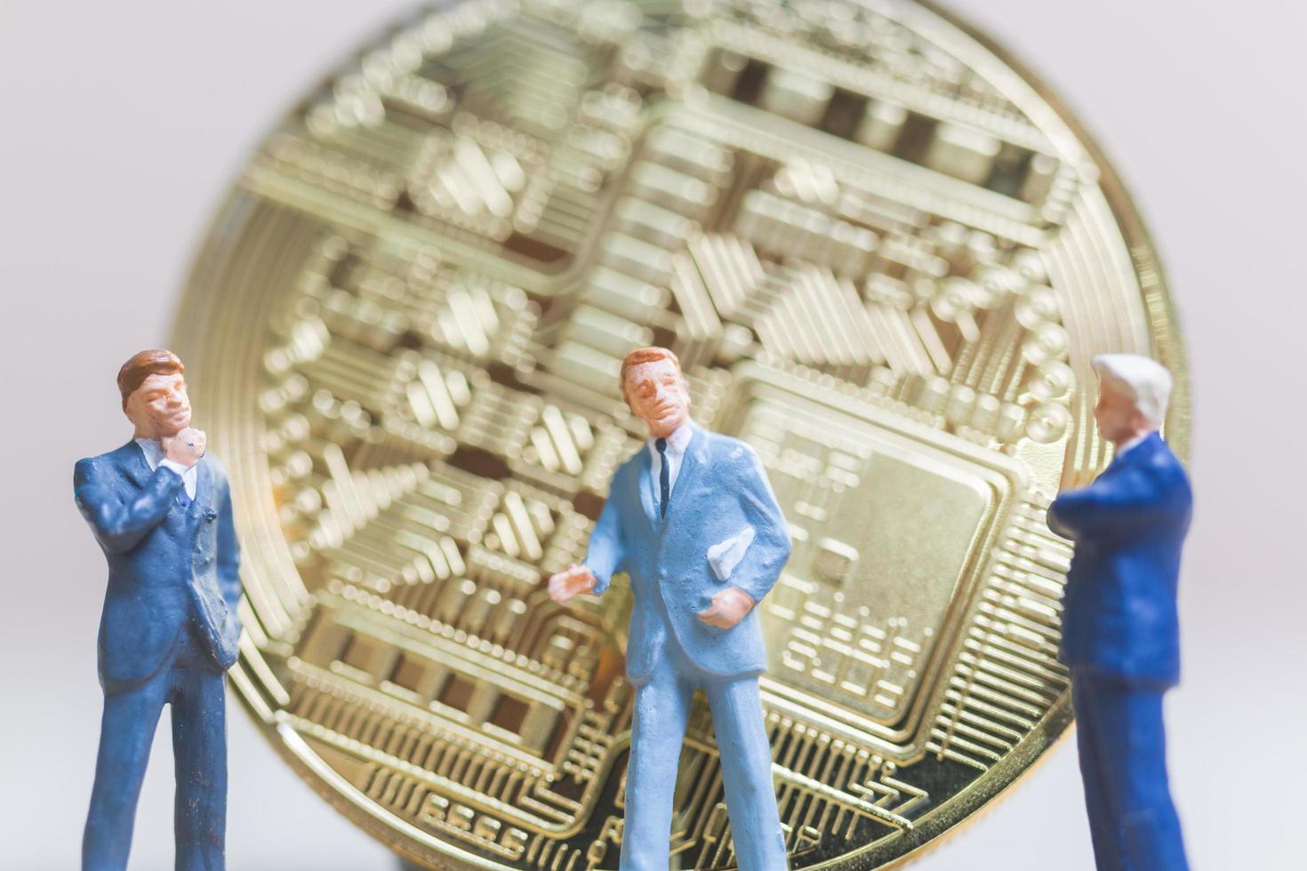 miniatyraffärsmän som står framför ett bitcoin-kryptovalutamynt, affärsidé foto