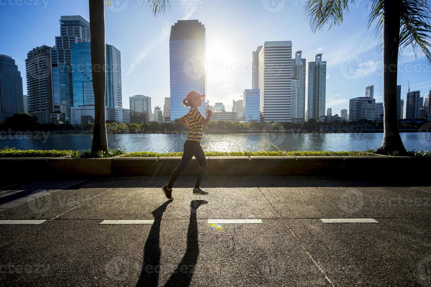 kvinna som kör i en stad under soluppgång foto
