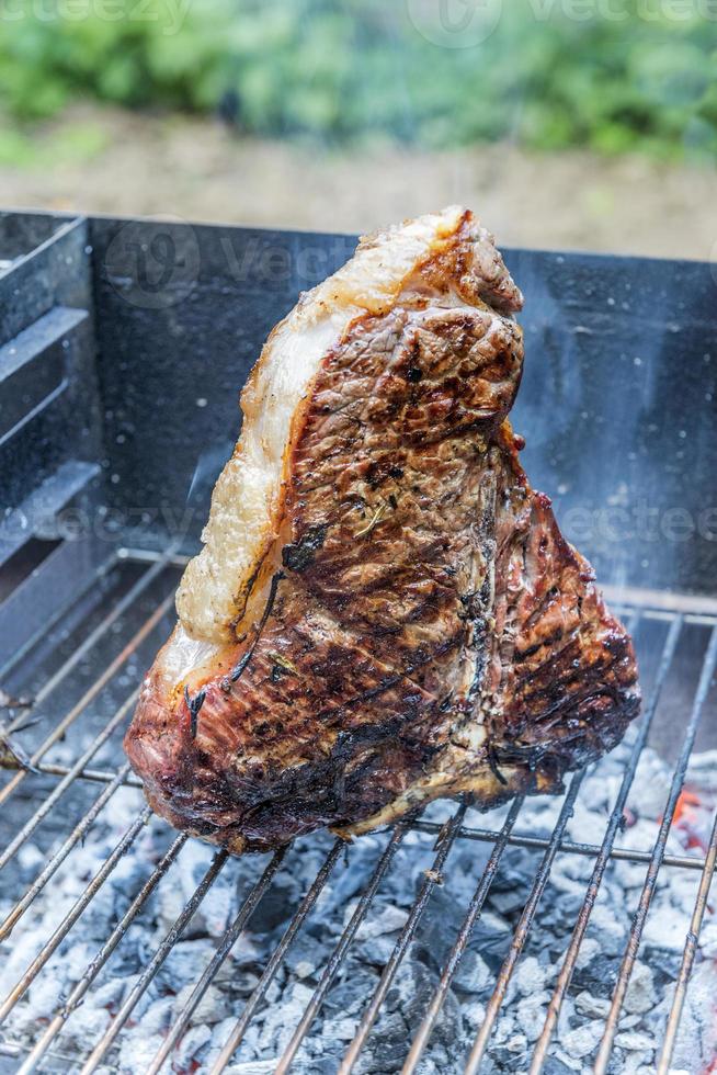 hela t-bone steak matlagning på grillen foto