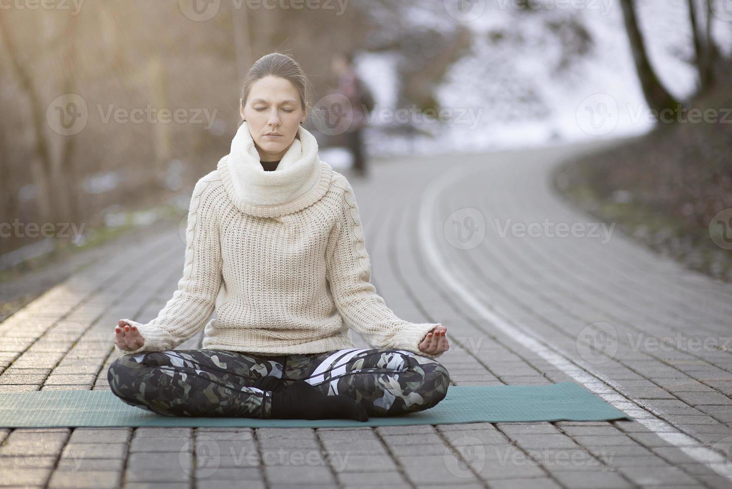 en ung atletisk kvinna utför yoga- och meditationsövningar utomhus foto