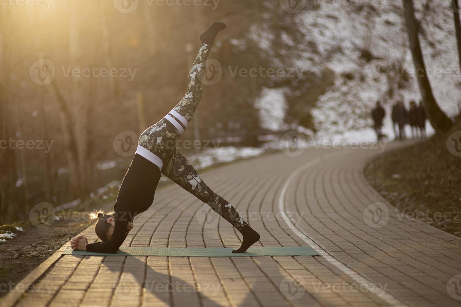 en ung atletisk kvinna utför yoga- och meditationsövningar utomhus foto