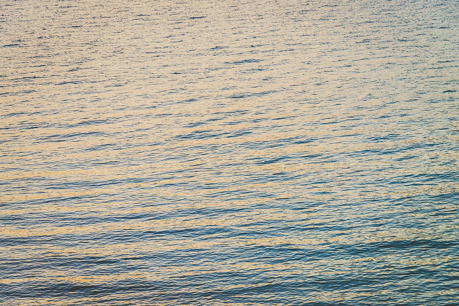 havsvatten bakgrund vid solnedgången foto