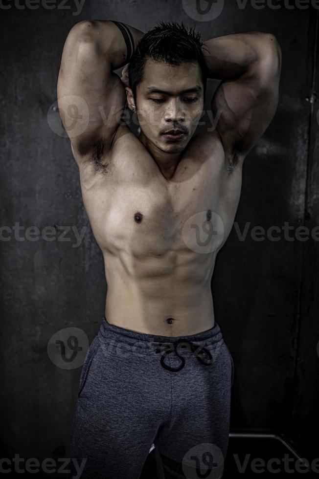 porträtt av asiatisk man stor muskel på gymmet, thailändska människor, träning för bra hälsa, kroppsviktsträning, fitness på gymkonceptet foto