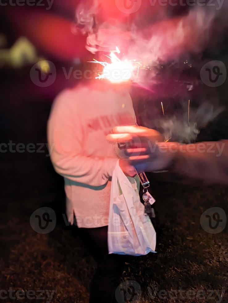 människor innehav sparklers i händer firar en Semester foto
