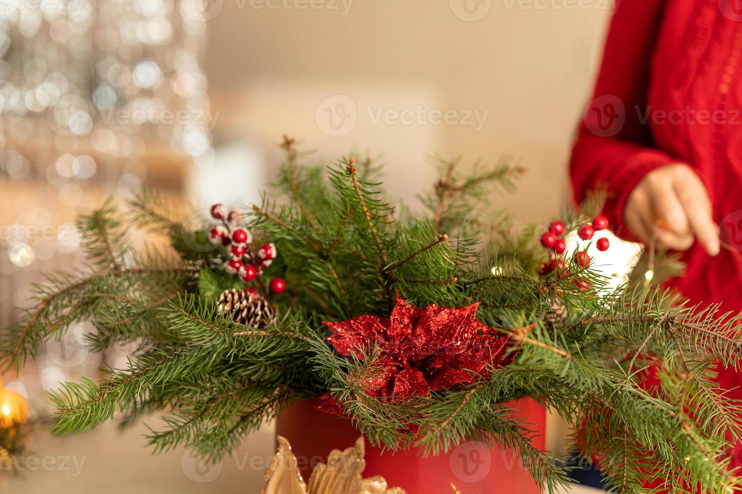 flicka samlar en jul bukett av gran grenar, blommor och jul träd dekorationer foto