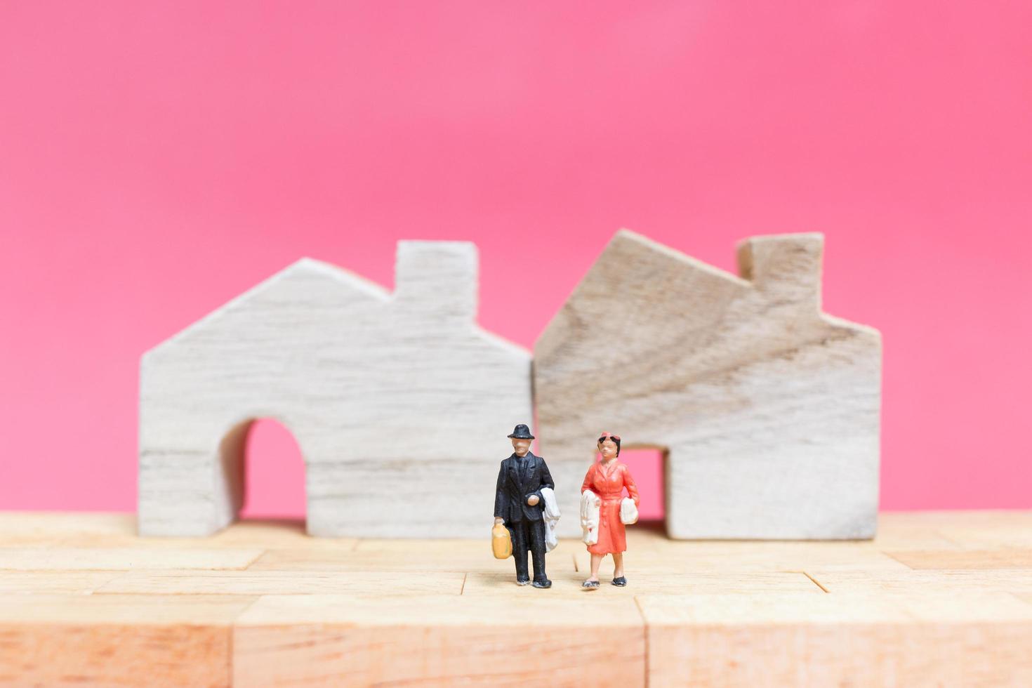 miniatyrpar med hus på rosa bakgrund, alla hjärtans dagskoncept foto