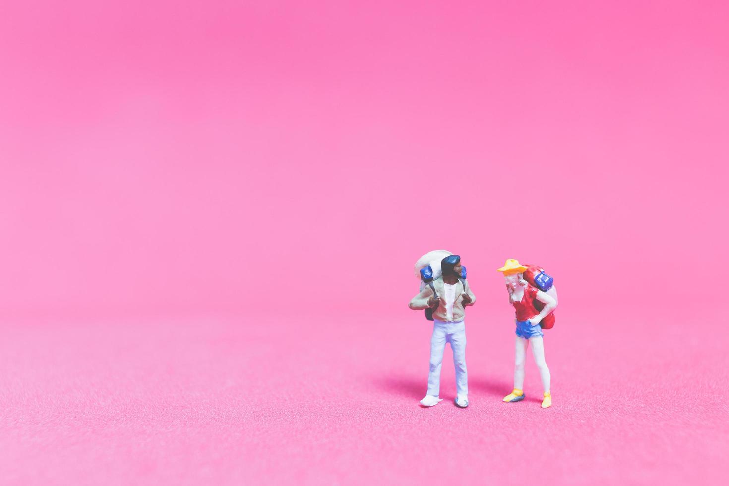 miniatyrpar av resenärer på rosa bakgrund foto