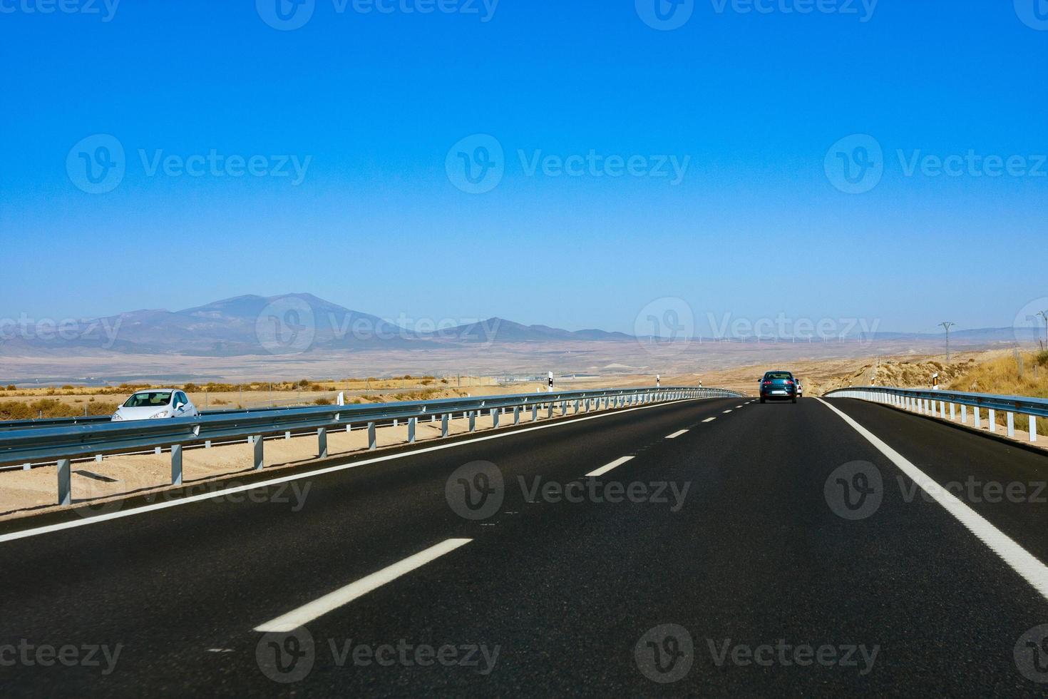 motorväg i de mitten av de torkades fält med bergen i de bakgrund. Spanien foto