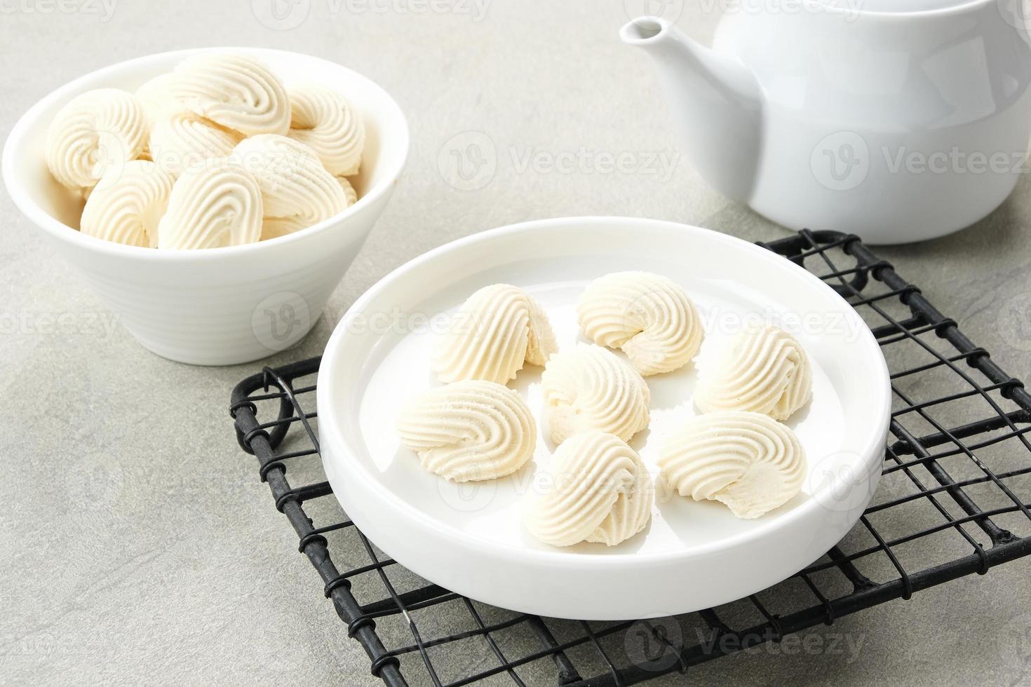 maräng småkakor i vit skål, tillverkad från vispad mjöl med socker och ägg foto
