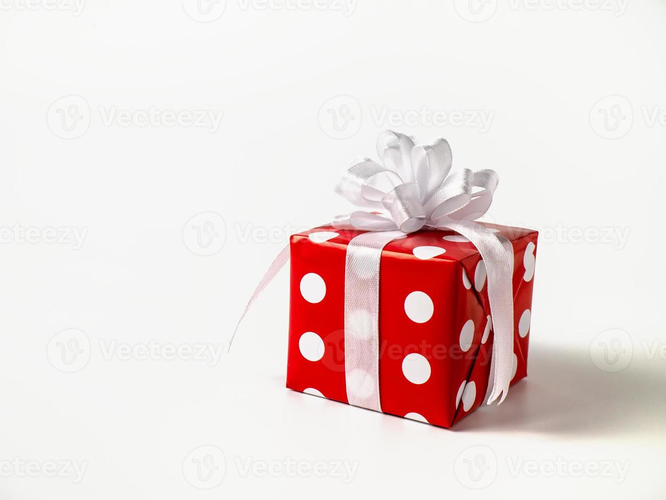 överraskning gåva för ny år, jul, födelsedag, älskad. röd polka punkt låda med stor rosett på vit bakgrund. foto