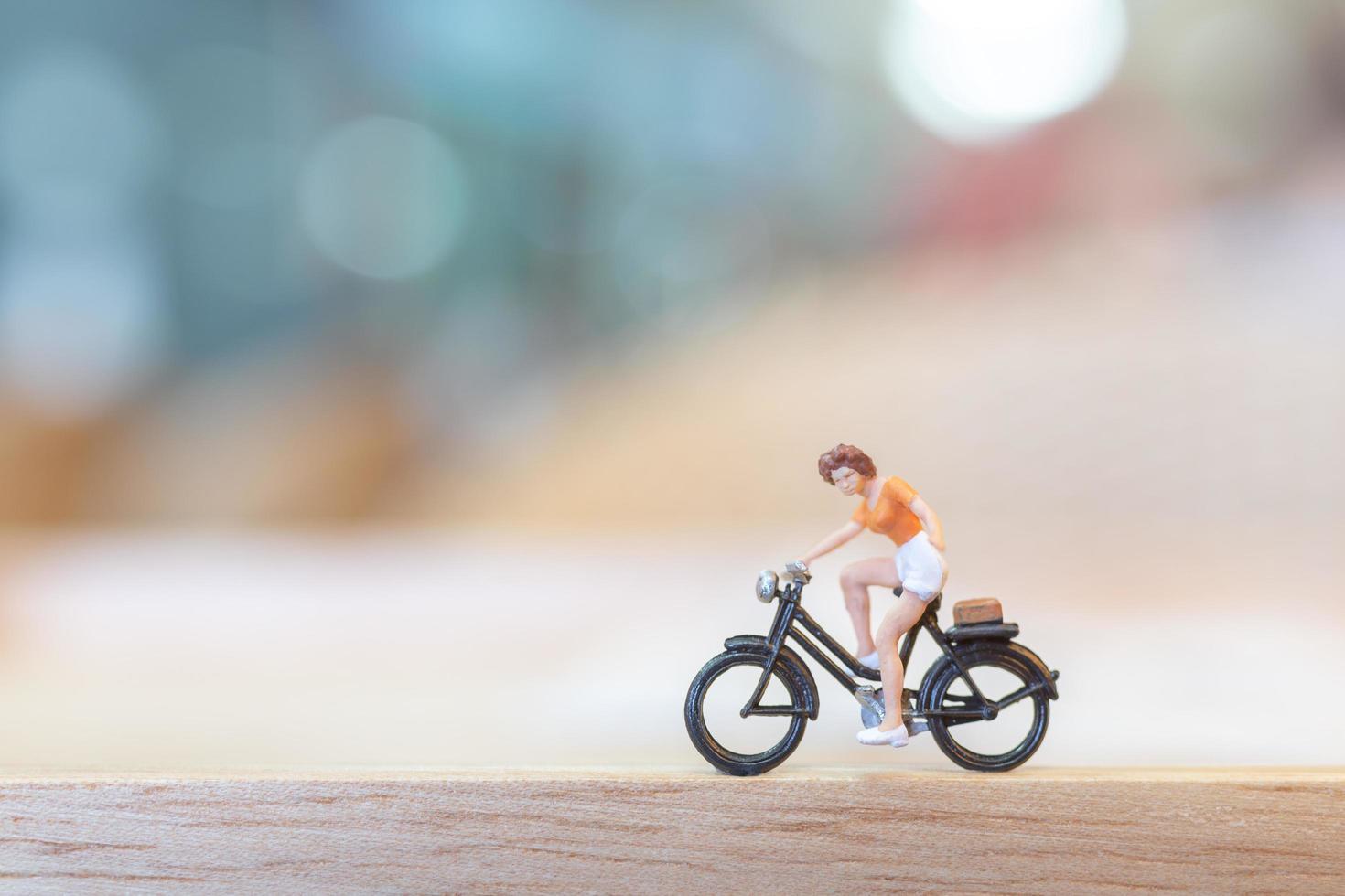 miniatyr person cykling på en träbro, hälsovård koncept foto