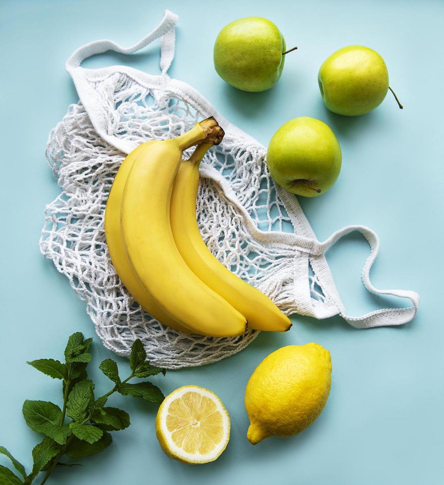saftiga mogna citrusfrukter och bananer i en miljövänlig shoppingkasse foto