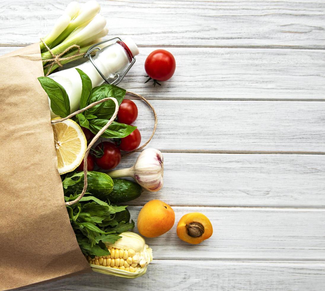 hälsosam mat i papperspåse, grönsaker och frukt foto