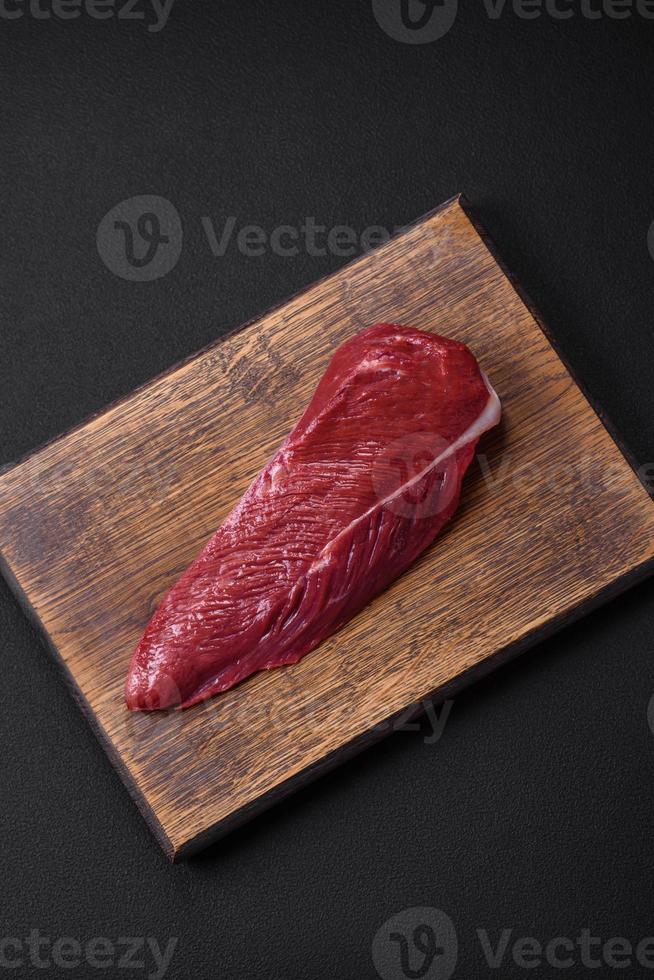 skön färsk bit av rå nötkött på en trä- skärande styrelse foto