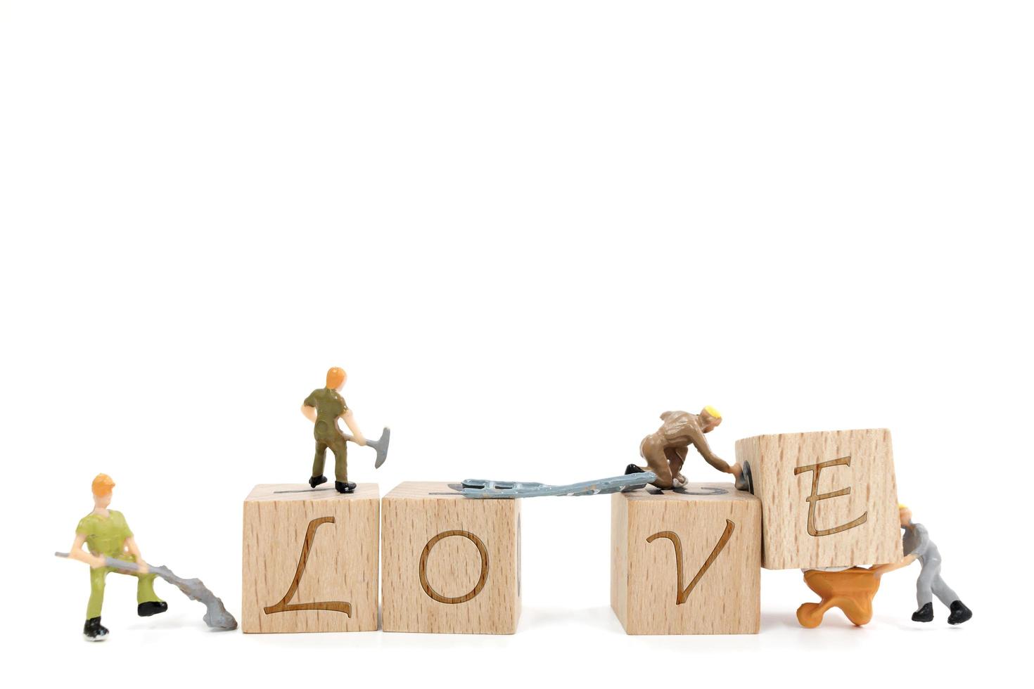 miniatyrarbetare som bygger ordet kärlek på en vit bakgrund foto