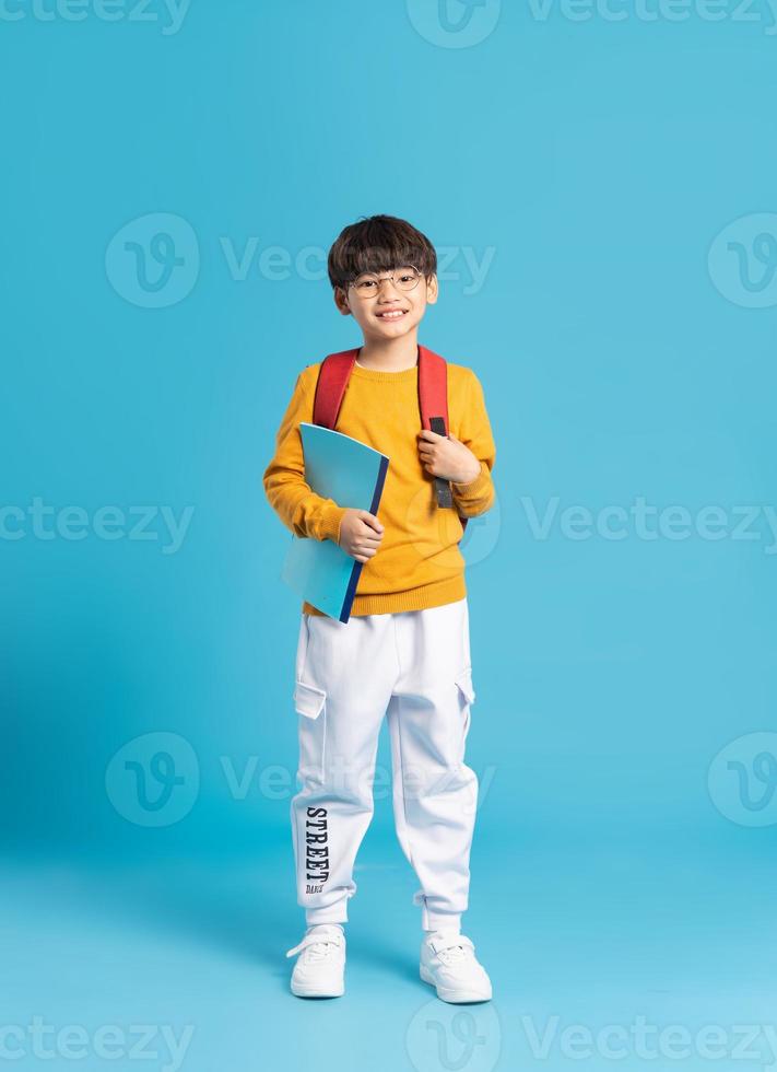 porträtt av asiatisk skola pojke född på en blå bakgrund foto