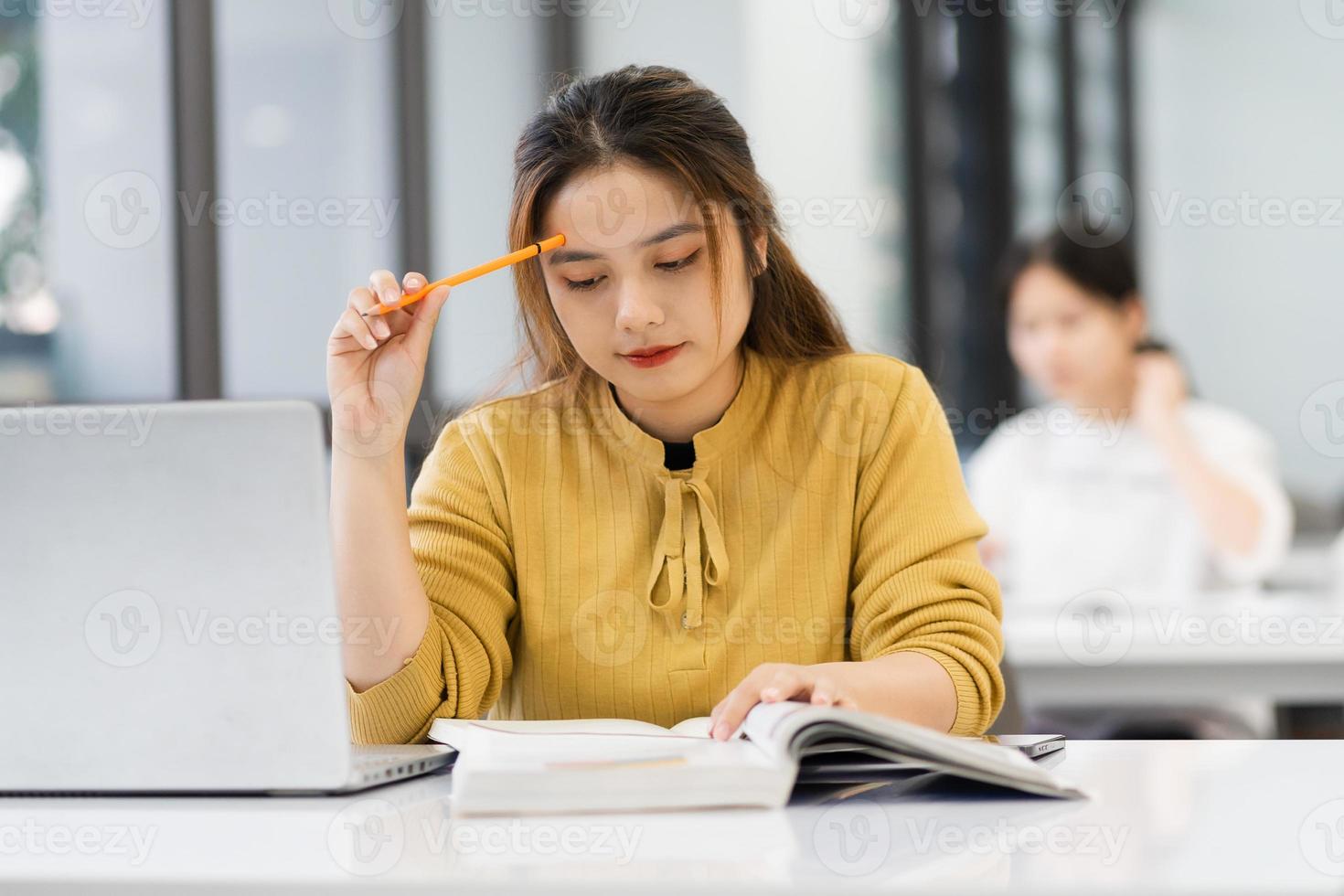 porträtt av asiatisk kvinna studerande studerar på universitet bibliotek foto