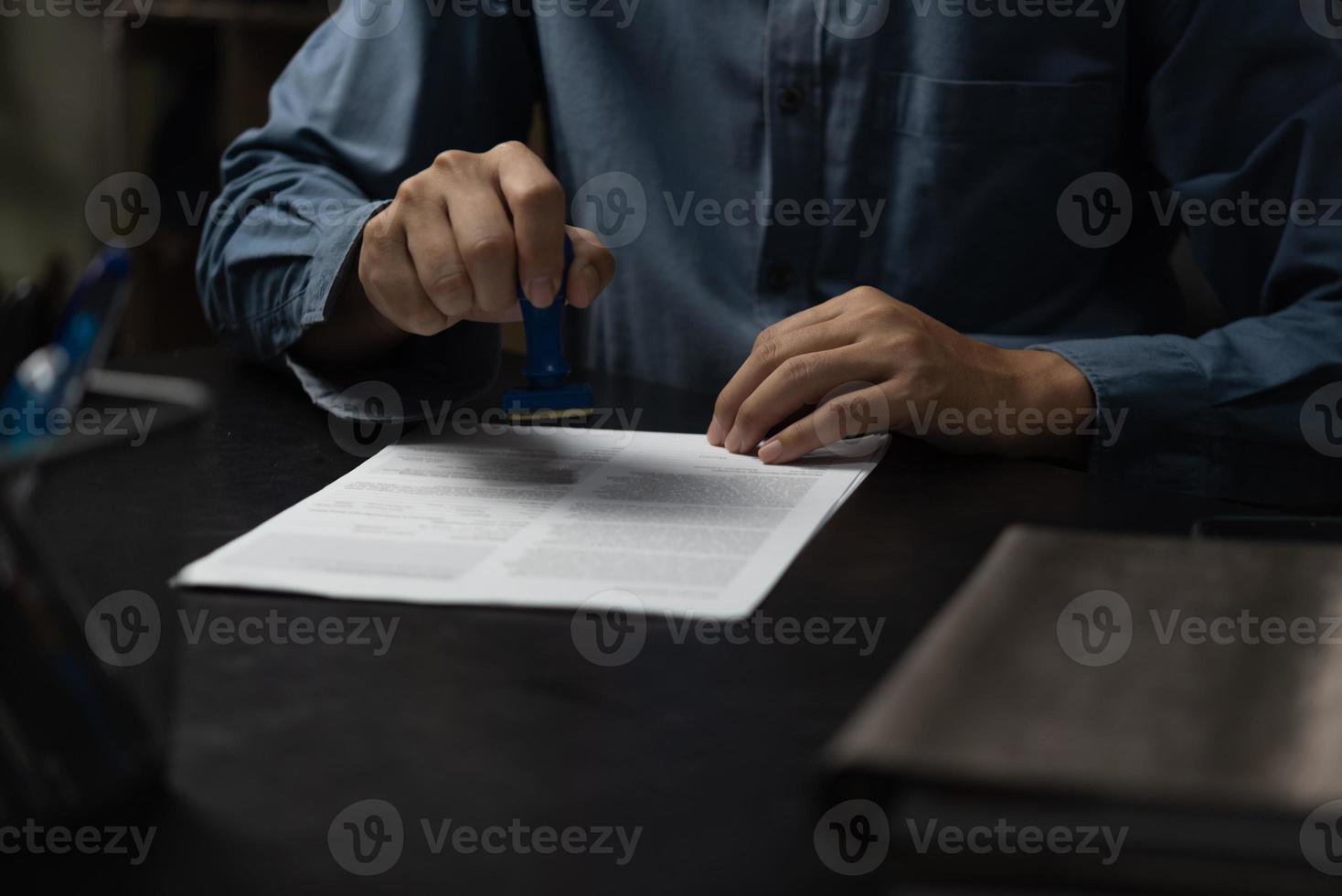 man stämpling godkännande av arbete finansiera bank eller investering marknadsföring dokument på skrivbord. foto